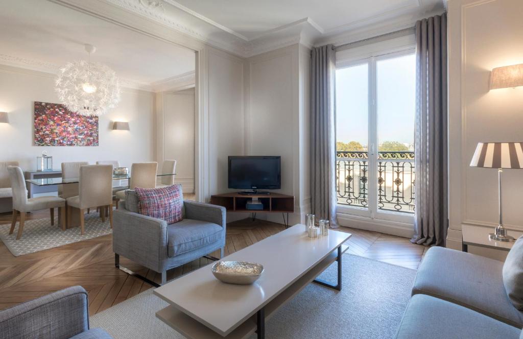 a living room with a couch and a dining room at Résidence Charles Floquet in Paris