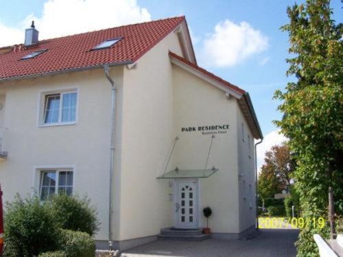 una pequeña casa blanca con techo rojo en Park Residence, en Garching bei München