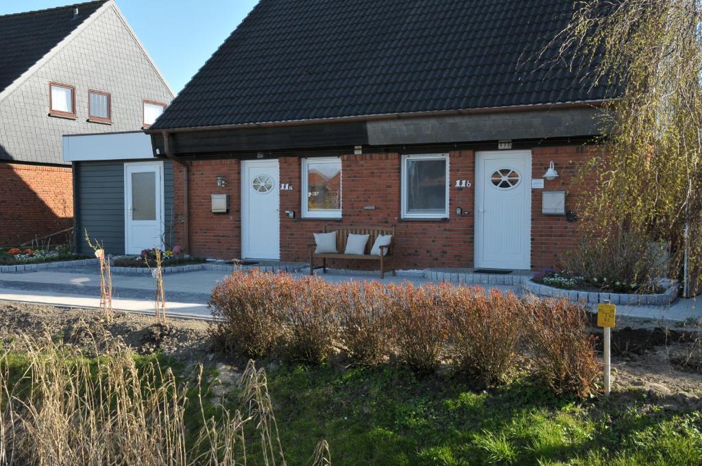 a brick house with a bench in front of it at Nonnenganshauser in Friedrichskoog