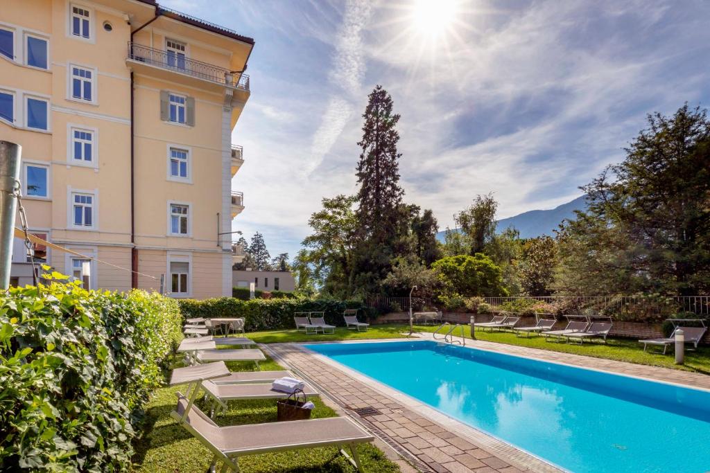 a swimming pool in front of a building at Hotel Kolping in Merano