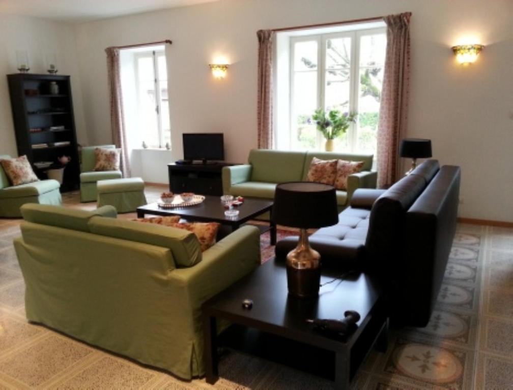 ein Wohnzimmer mit Sofas und einem Tisch in der Unterkunft Gite Allier in Montaigu-le-Blin