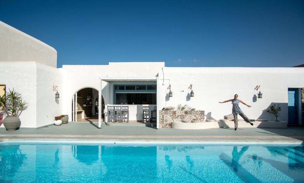 un hombre saltando a una piscina frente a una casa en Mouras Resort en Livadi Astypalaias