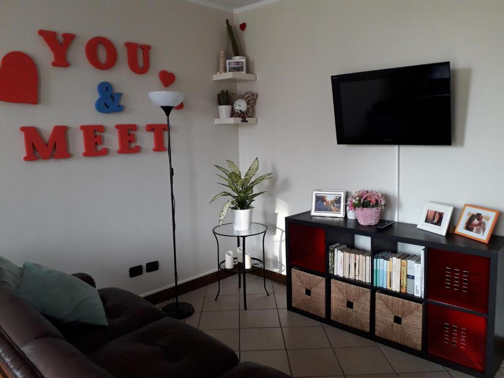 een woonkamer met een bank en een flatscreen-tv bij IEO - HUMANITAS - MILANO CENTRO a 15 minuti in Locate di Triulzi