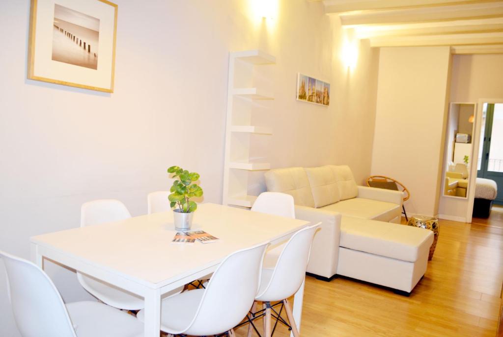 une salle à manger blanche avec une table et des chaises blanches dans l'établissement Barcelona Mercaders Apartments, à Barcelone