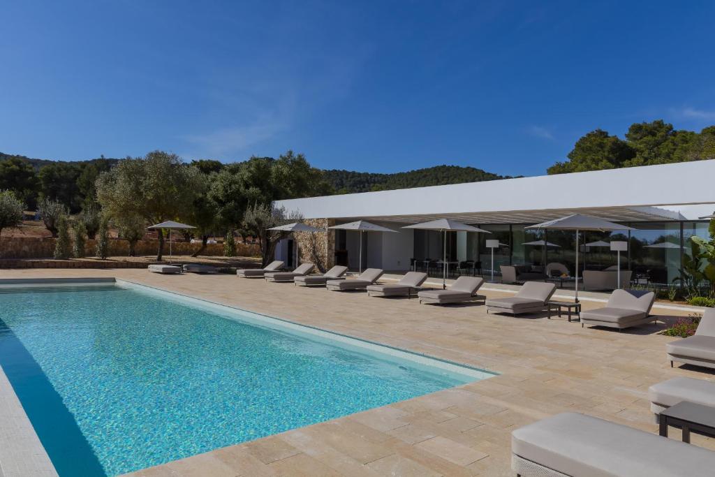 una piscina con tumbonas y una villa en Villa Calma, en Sant Llorenç de Balàfia