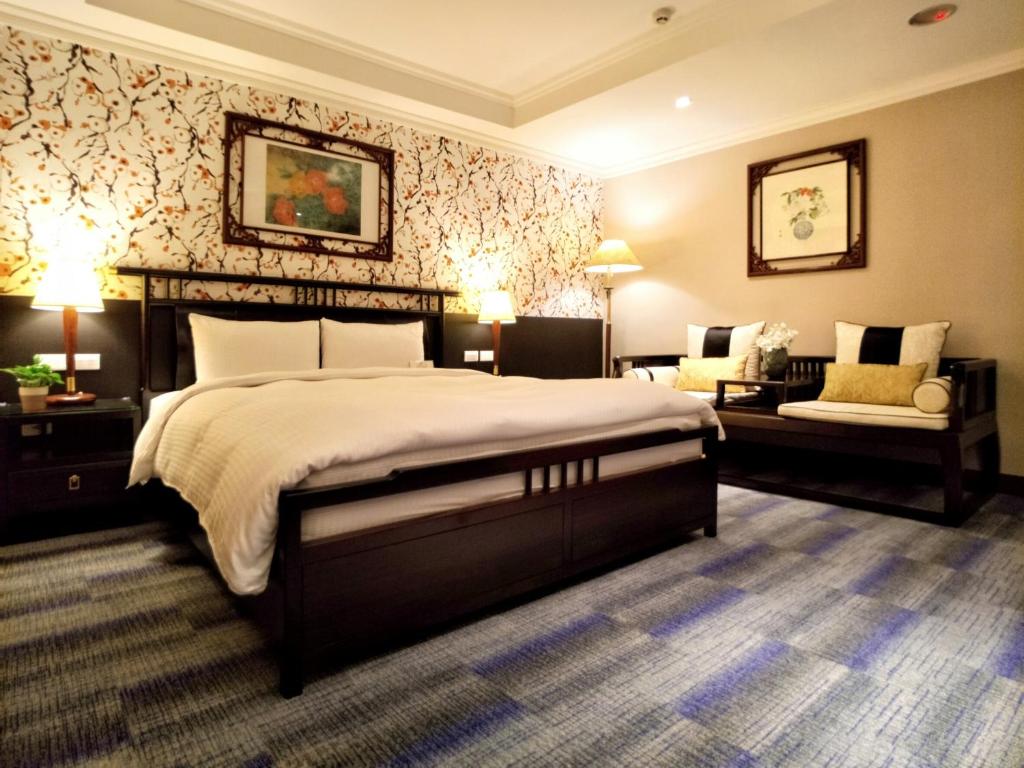 a bedroom with a large bed and a chair at Beauty Hotels - Star Beauty Resort in Taipei