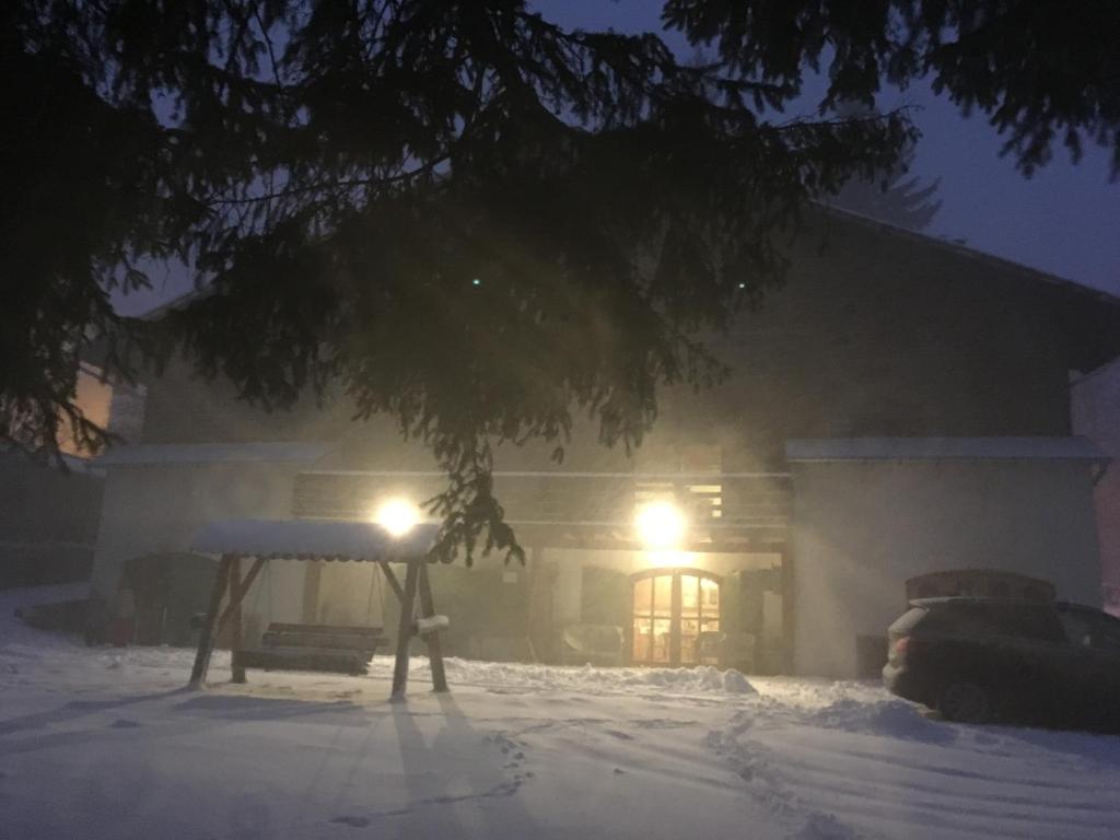 a house in the snow at night at Charming Chalet Timisu de Sus in Predeal