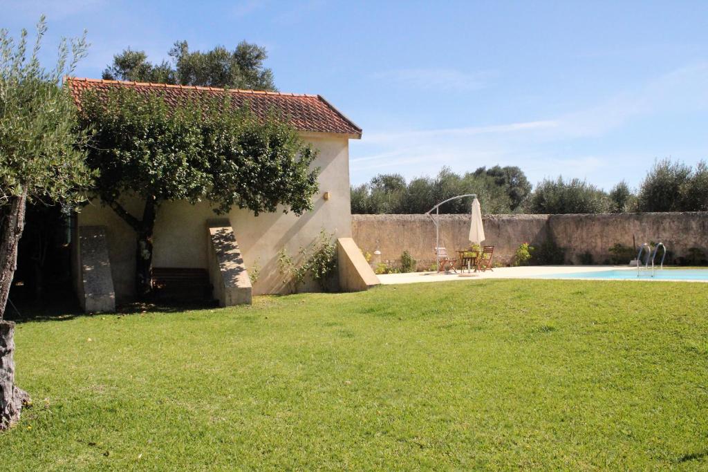 a house and a yard with a swimming pool at ADOBE TYPICAL COTTAGE in AlpalhÃ£o