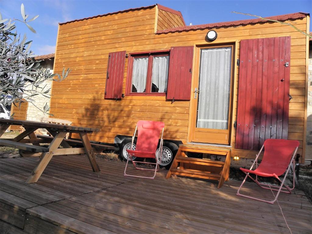 a tiny house with two chairs and a picnic table at Provence Roulottes in Barbentane