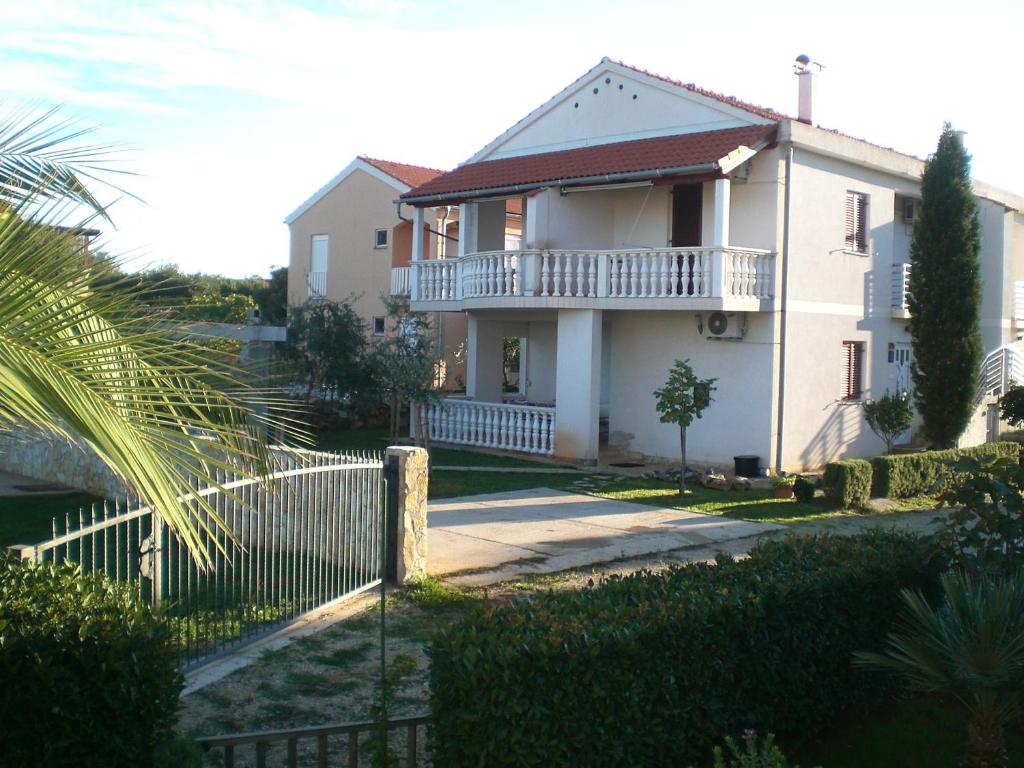 une maison blanche avec une clôture devant elle dans l'établissement Bava, à Ugljan