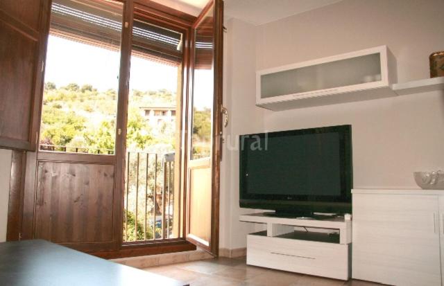 salon z telewizorem i dużym oknem w obiekcie Apartamento Angel e Isabel w mieście Alquézar