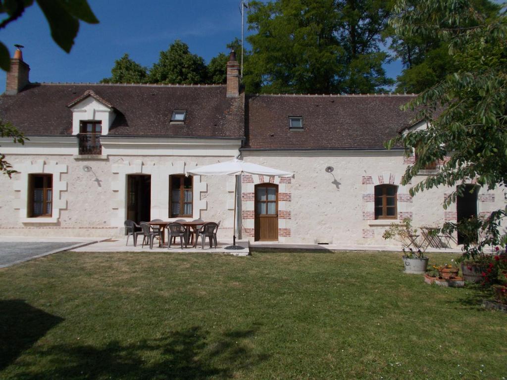 ein Haus mit einem Tisch und Stühlen im Hof in der Unterkunft gite du haut du bourg in Veuil