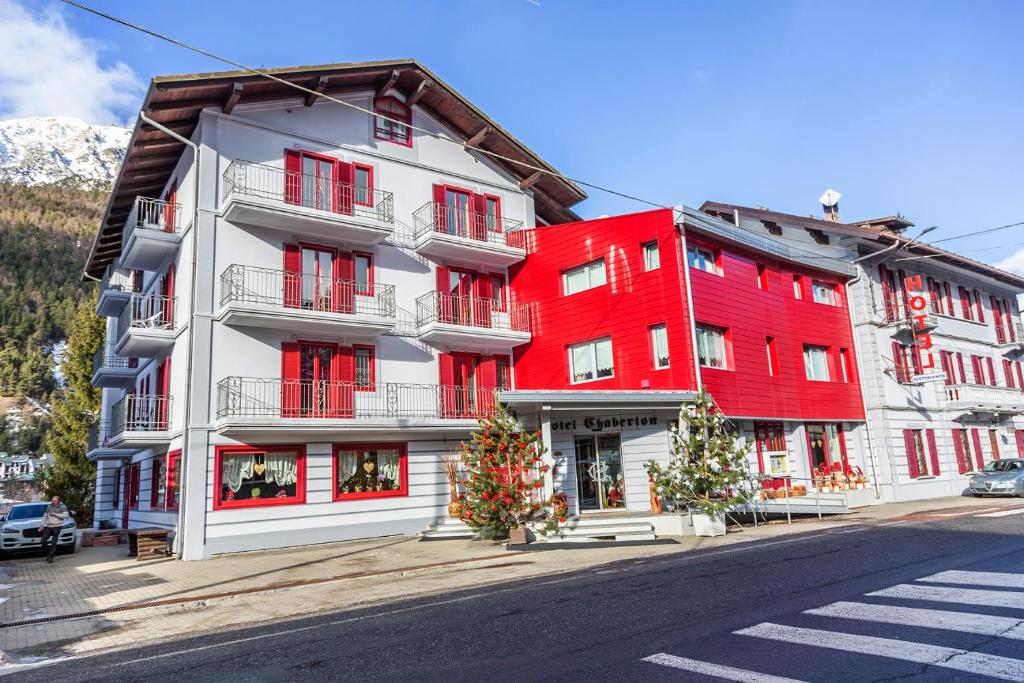 czerwony budynek po stronie ulicy w obiekcie Hotel Chaberton w mieście Cesana Torinese