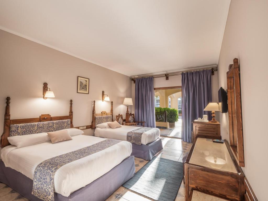 um quarto de hotel com duas camas e uma janela em Sunny Days Palma De Mirette Resort & Spa em Hurghada