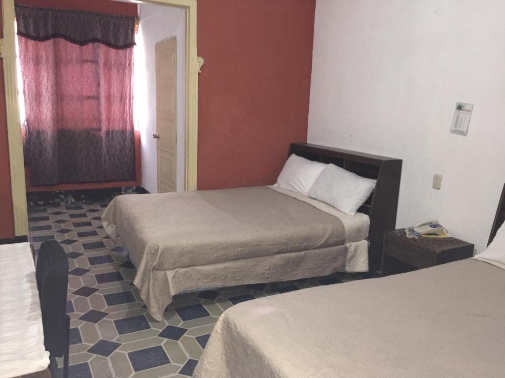 a hotel room with two beds and a window at Hotel Mayesstic in Guatemala