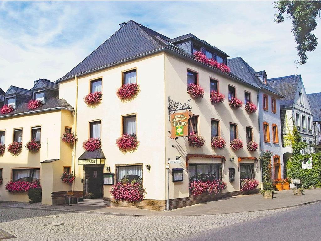 a large white building with flower boxes on it at Hotel Alt Cues in Bernkastel-Kues