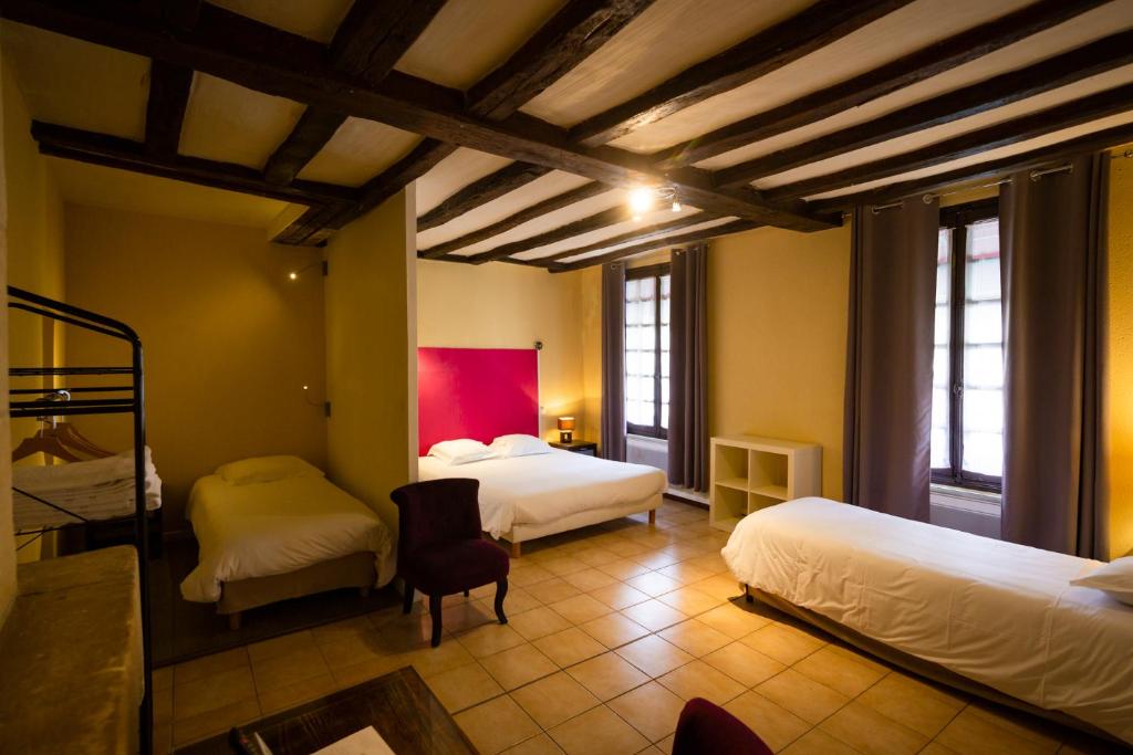 1 dormitorio con 2 camas, mesa y sillas en Hotel Les Trois Lys, en Azay-le-Rideau