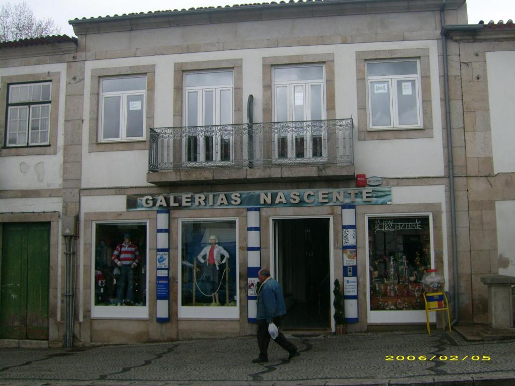 un homme marchant devant un bâtiment dans l'établissement Alojamento Galerias Nascentes, à Alijó