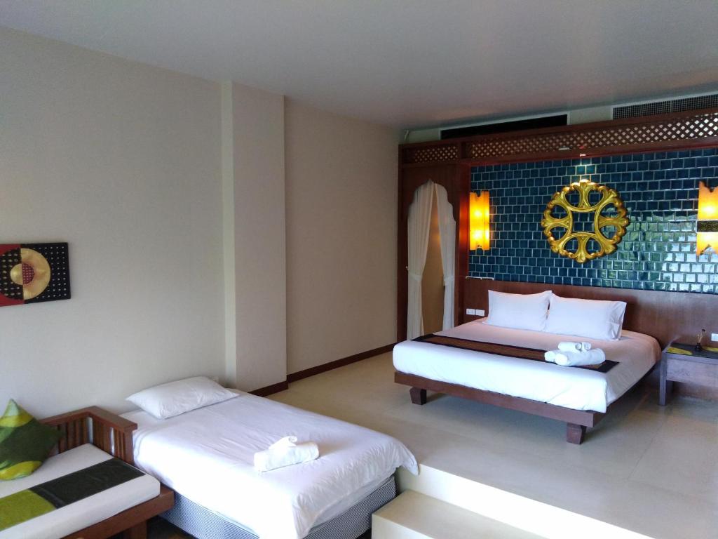 una camera d'albergo con due letti e un tavolo di C-VIEW BOUTIQUE a Rawai Beach