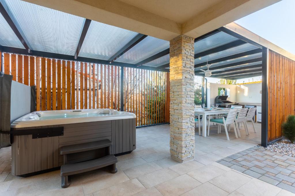 an outdoor patio with a tub and a dining area at Apartment Solinar in Soline