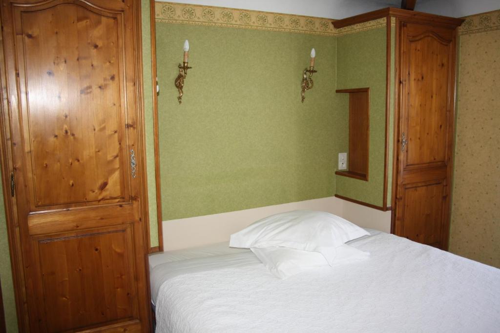 a bedroom with a bed and a wooden cabinet at La Marjolaine in Juan-les-Pins