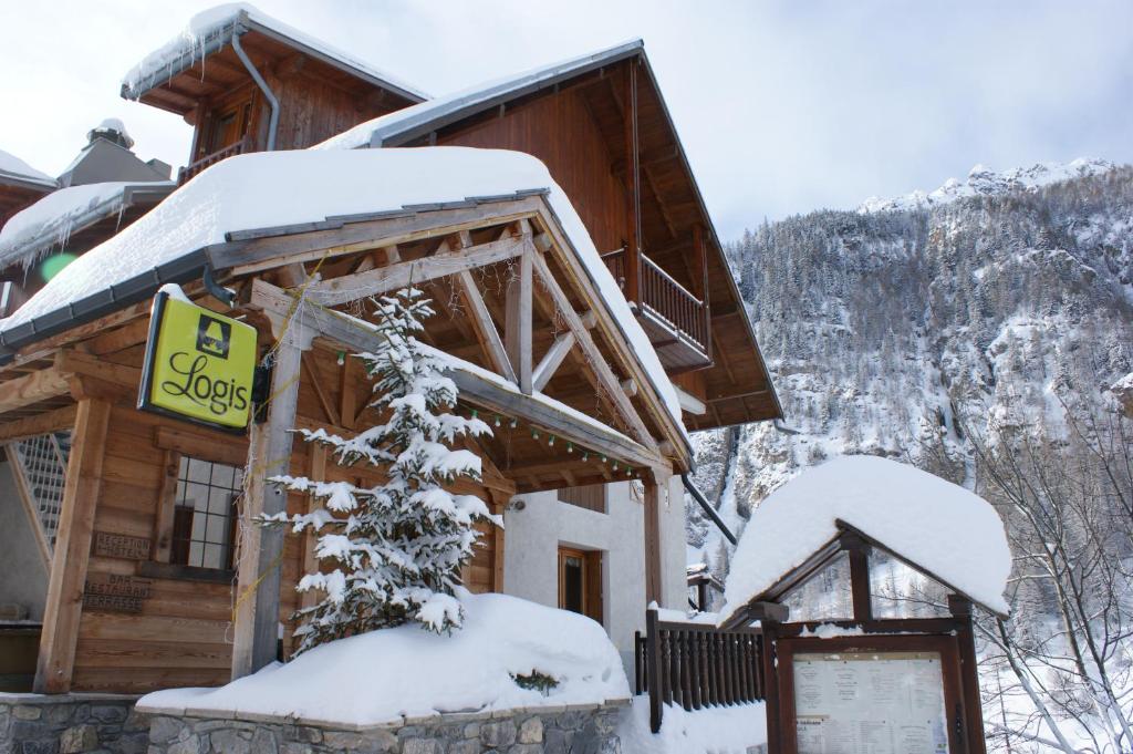 ein Blockhaus im Schnee mit einem Schild drauf in der Unterkunft Hôtel Spa la Cascade in Ceillac