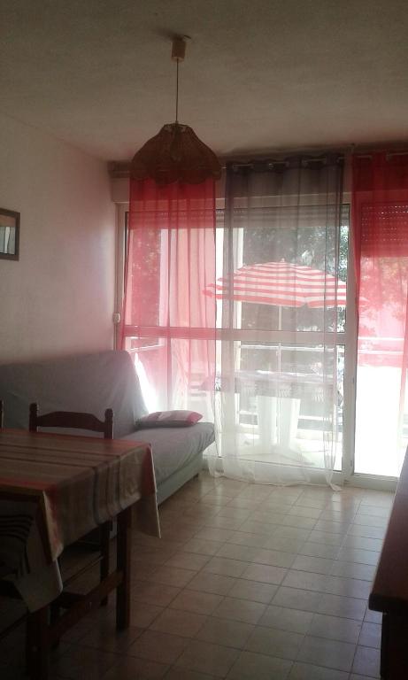 un salon avec un canapé et quelques fenêtres dans l'établissement 84 Rue du Vieux Village, à Carnon-Plage