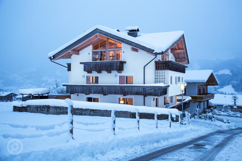 a house covered in snow with a fence at Apartment Eberharter in Fügenberg