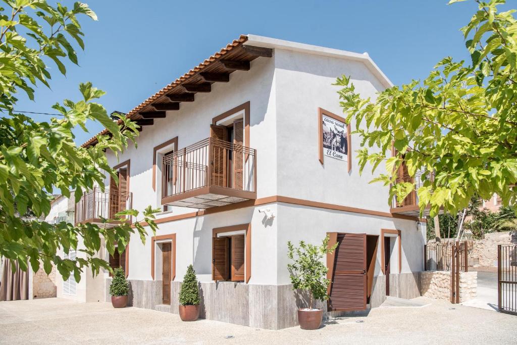 Casa blanca con balcón y árboles en Casa Rural El Cano en Fortuna