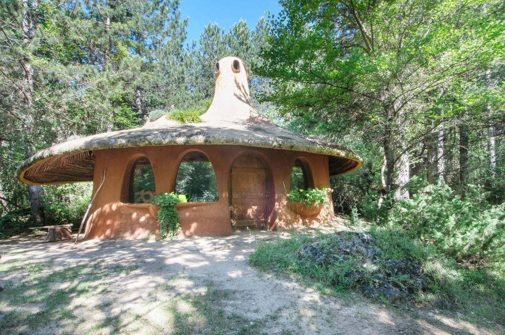 a house with a thatched roof in the woods at Omaya Eco Village in Gaytaninovo