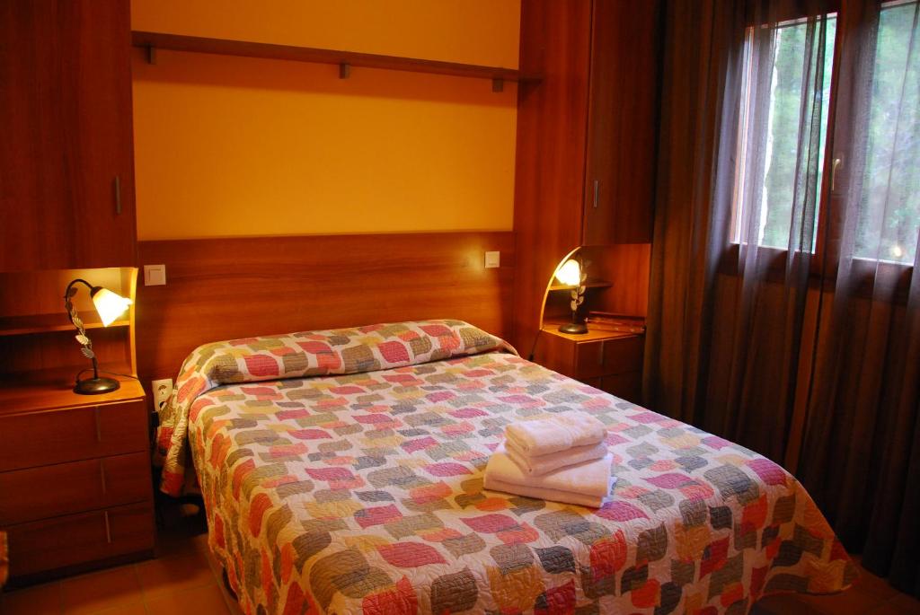 a bedroom with a bed with two towels on it at Camping El Roble in Valderrobres