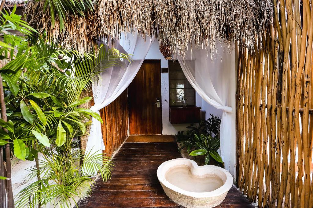 a bathroom with a heart shaped toilet in a room with plants at The Beach Tulum Hotel in Tulum