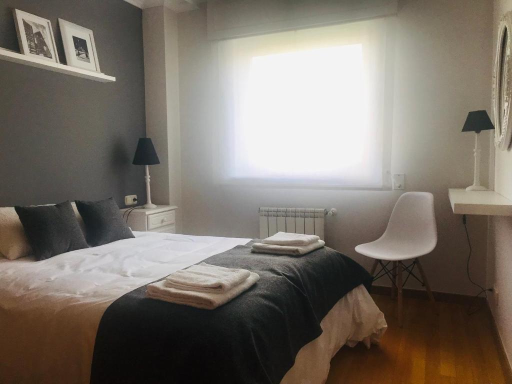 a bedroom with a bed with two towels on it at Descanso do Sar in Santiago de Compostela