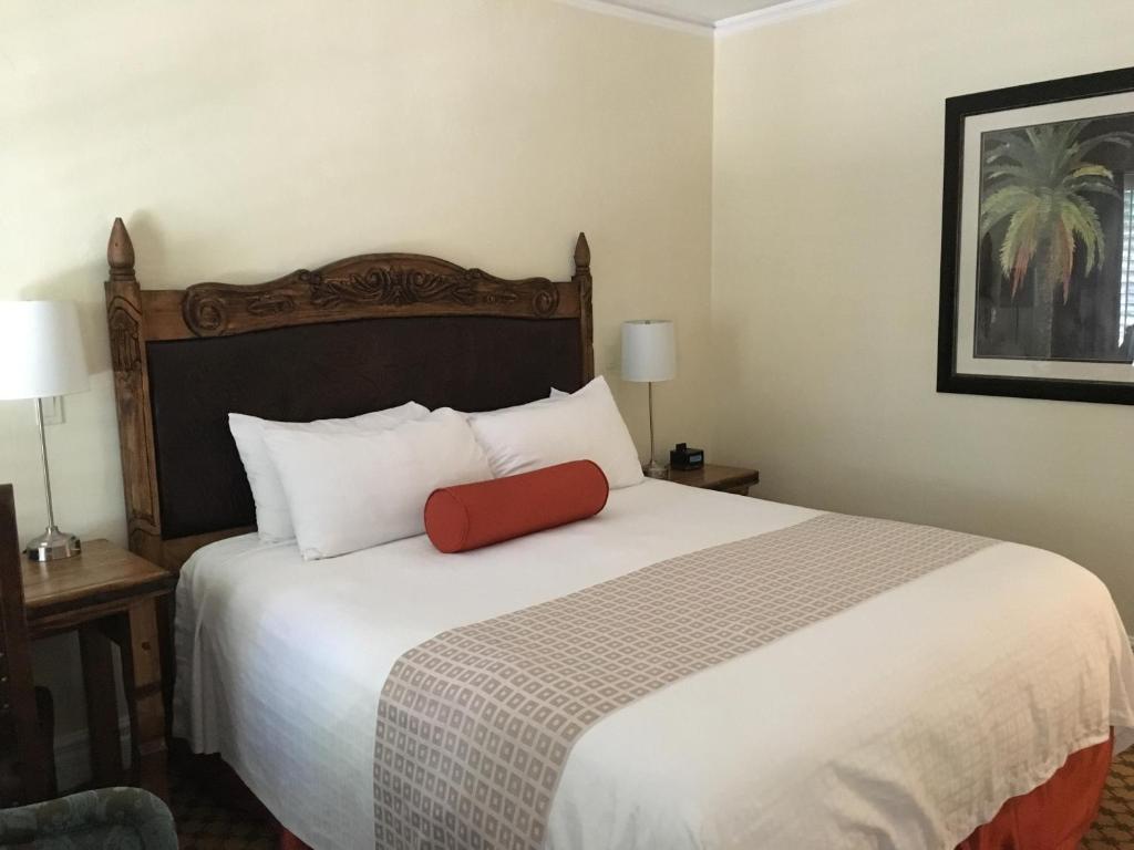 a bedroom with a large bed with a red pillow on it at The Eagle Inn in Santa Barbara
