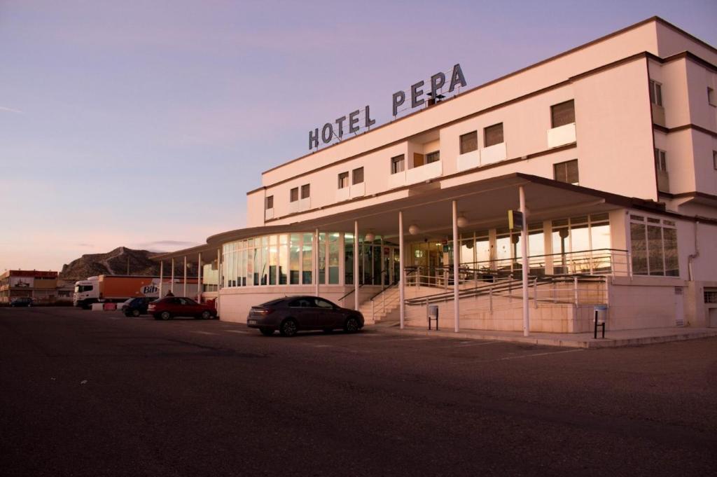 Un hotel pena con coches aparcados delante de él en Hotel Pepa, en Villafranca de Ebro