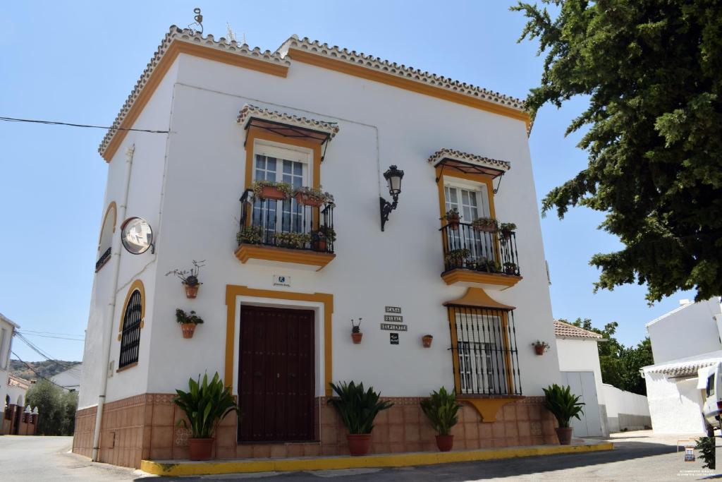 een wit gebouw met balkons in een straat bij Casa Rural El Puente in Cuevas del Becerro