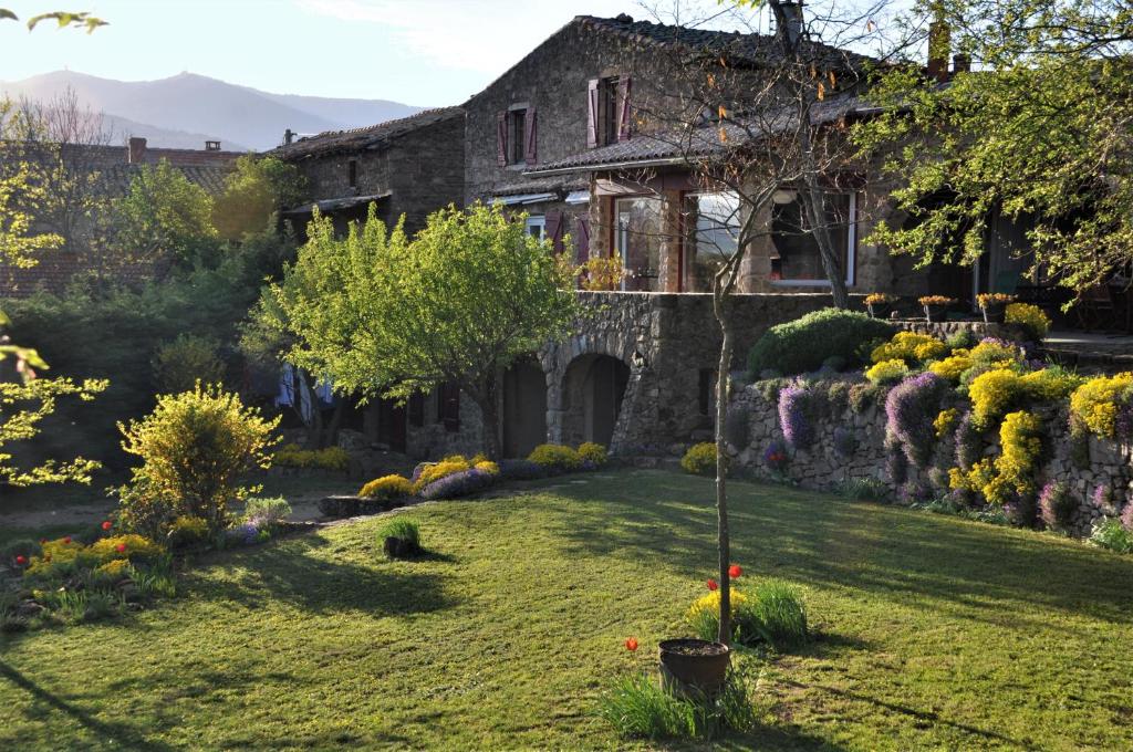 una antigua casa de piedra con jardín en el patio en Chambre d'hôtes de Thorée, en Maclas