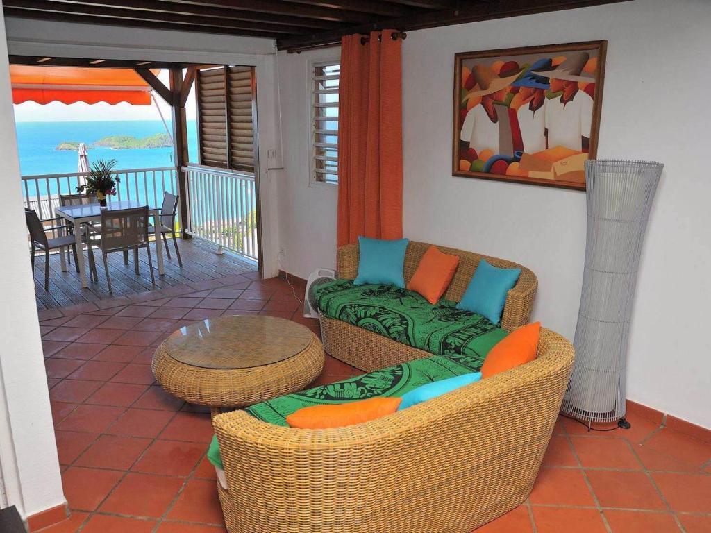 a living room with a couch and a table on a balcony at L'Eden Caraïbe in Pigeon