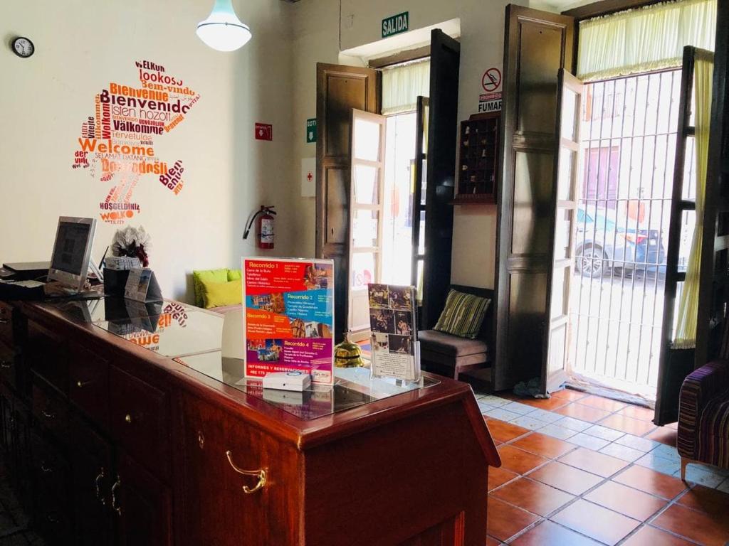 a lobby with a desk with a sign on the wall at Hostal Cielito De María in Zacatecas