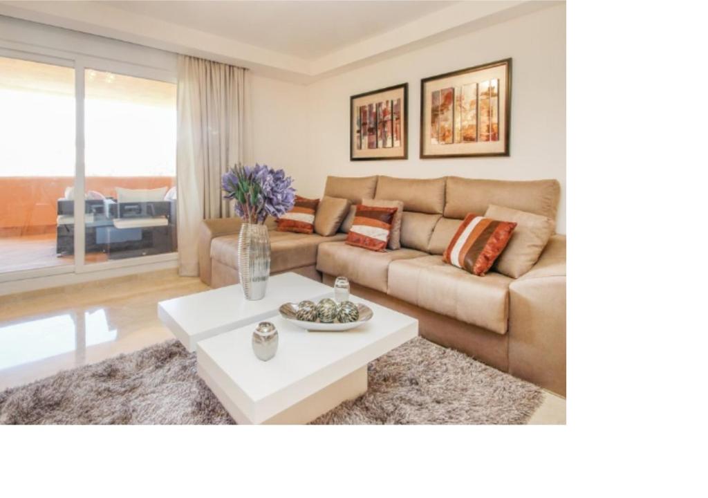 sala de estar con sofá y mesa en Cabopino, en Marbella