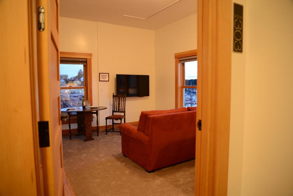 a living room with a red couch and a table at Inn At Creek Street in Ketchikan