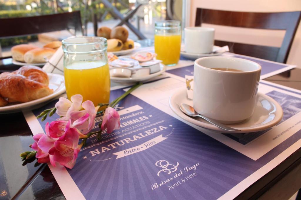 uma mesa com uma chávena de café e uma chávena de sumo de laranja em Brisas del Lago Apart y Hotel em Federación