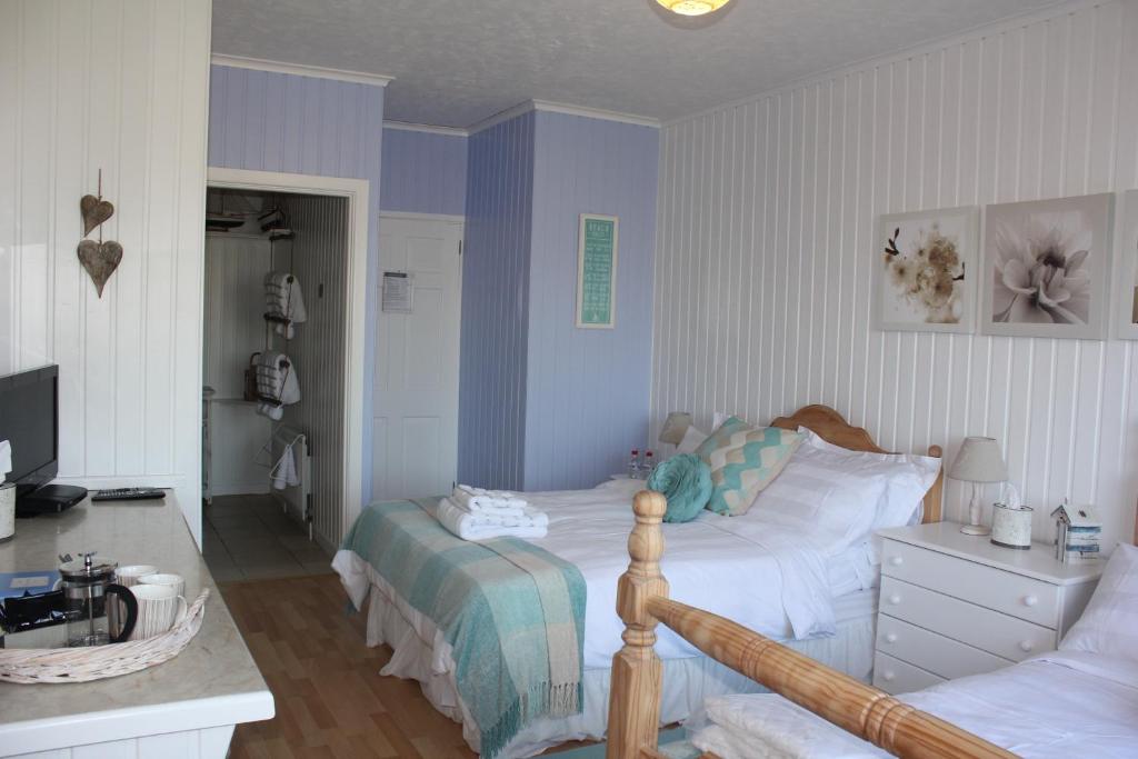 a bedroom with a bed and a desk and a television at Cairnview Bed and Breakfast in Larne