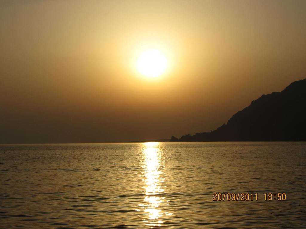 a sunset over the water with the sun in the sky at Anemoni Studios in Plakias