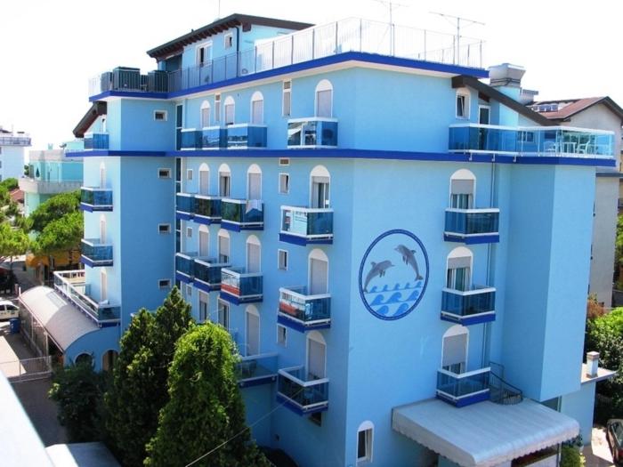 un edificio azul con un cartel en el costado en Hotel Ettoral en Lido di Jesolo