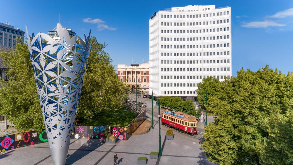 a street with a bus in a city with buildings at Distinction Christchurch Hotel in Christchurch