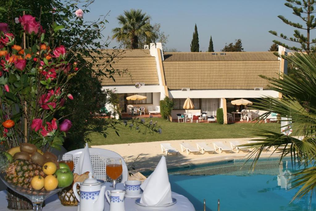 a table with fruit on it next to a pool at Capitalmoura Mouragolf Village in Vilamoura
