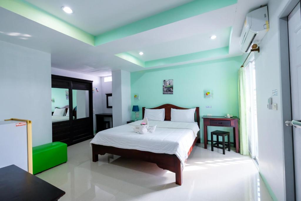 J Jamroon Place في ناخون راتشاسيما: غرفة نوم بسرير في غرفة بجدران زرقاء