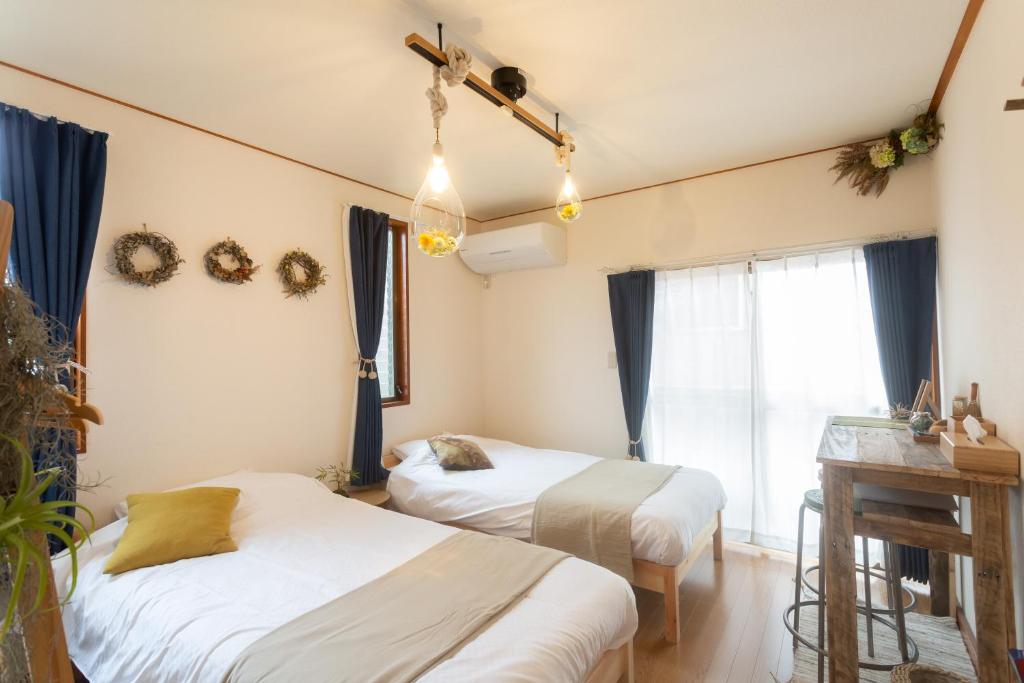 1 dormitorio con 2 camas y ventana en Tipy records inn, en Odawara