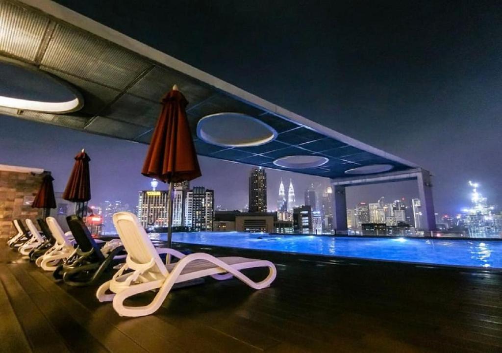 a rooftop bar with chairs and a view of the city at Maxhome @ D'Majestic Place, KL City Centre in Kuala Lumpur